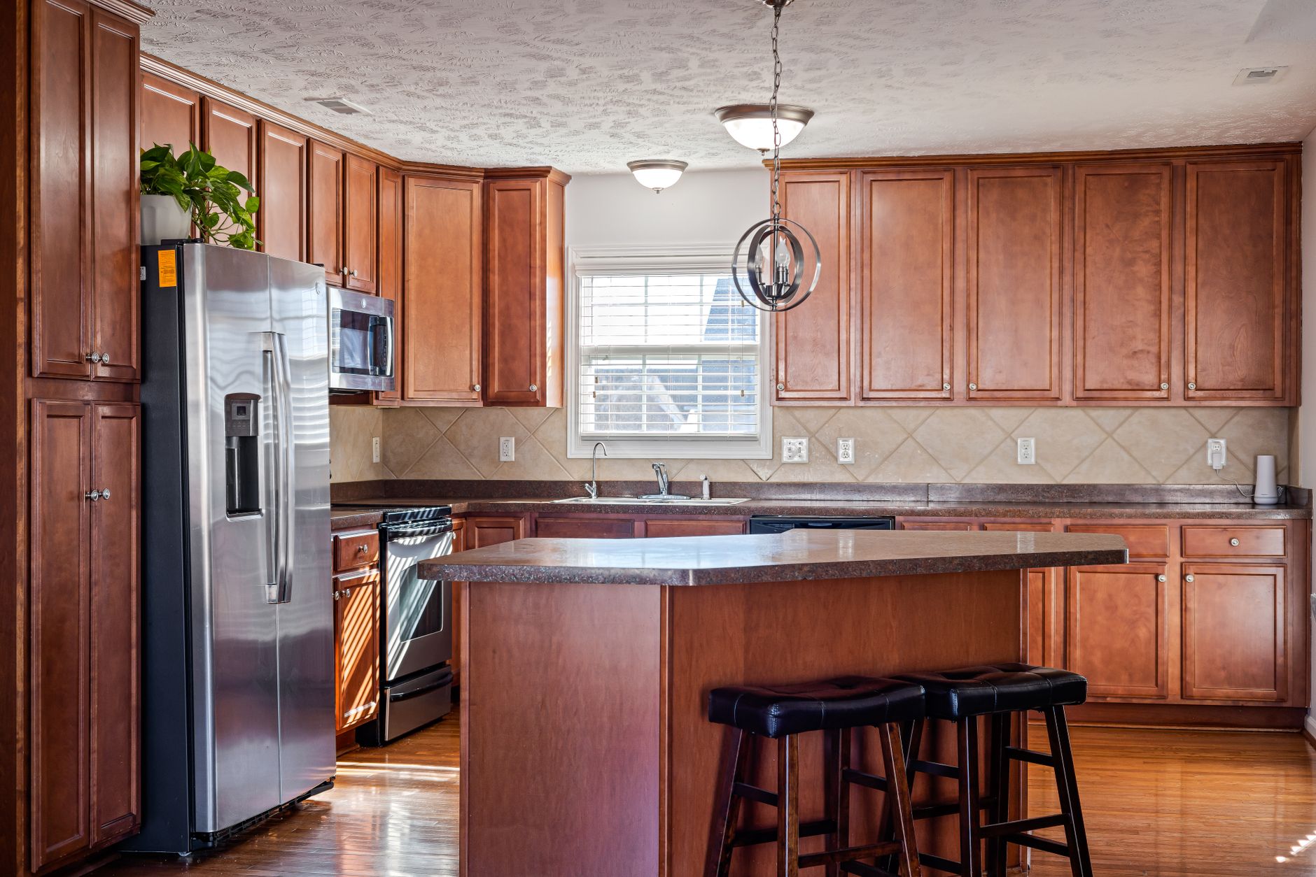 Spacious kitchen with wooden cabinets, island, and stainless appliances in Austin, TX