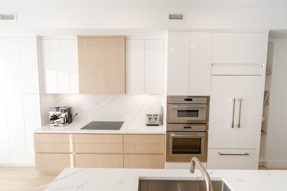 A sleek and modern kitchen with built-in appliances and marble countertops, offering a bright and clean aesthetic.